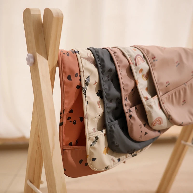 Babador Impermeável Infantil com Bolso Coletor Ajustável Estampas Variadas Unissex